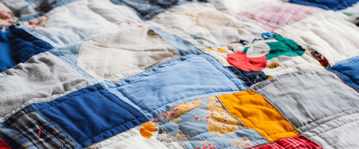 A blanket made form patches of old clothes in various colours and patterns
