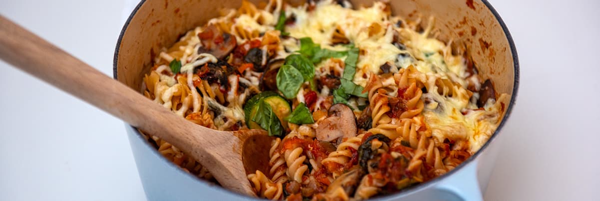 Pot o basta gyda saws a llwy bren